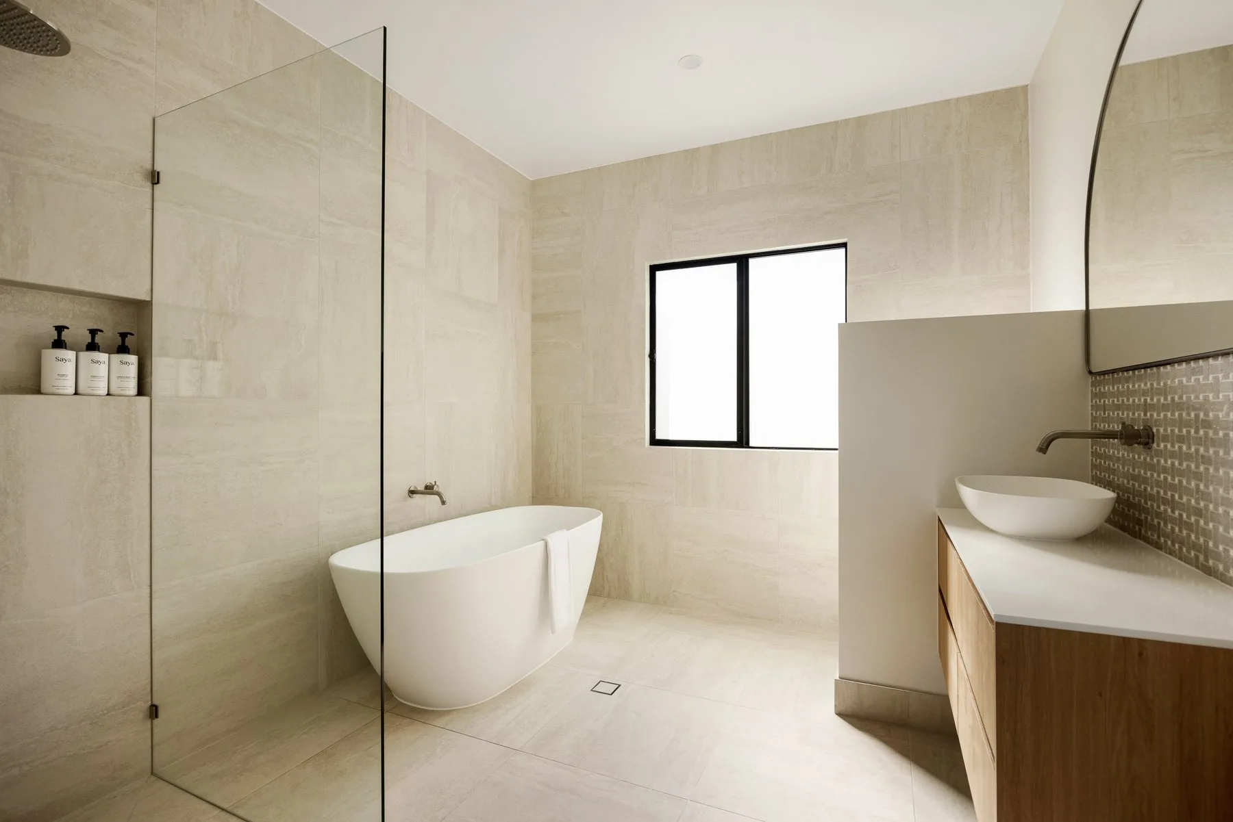 A bright bathroom with a freestanding bathtub and a vanity.