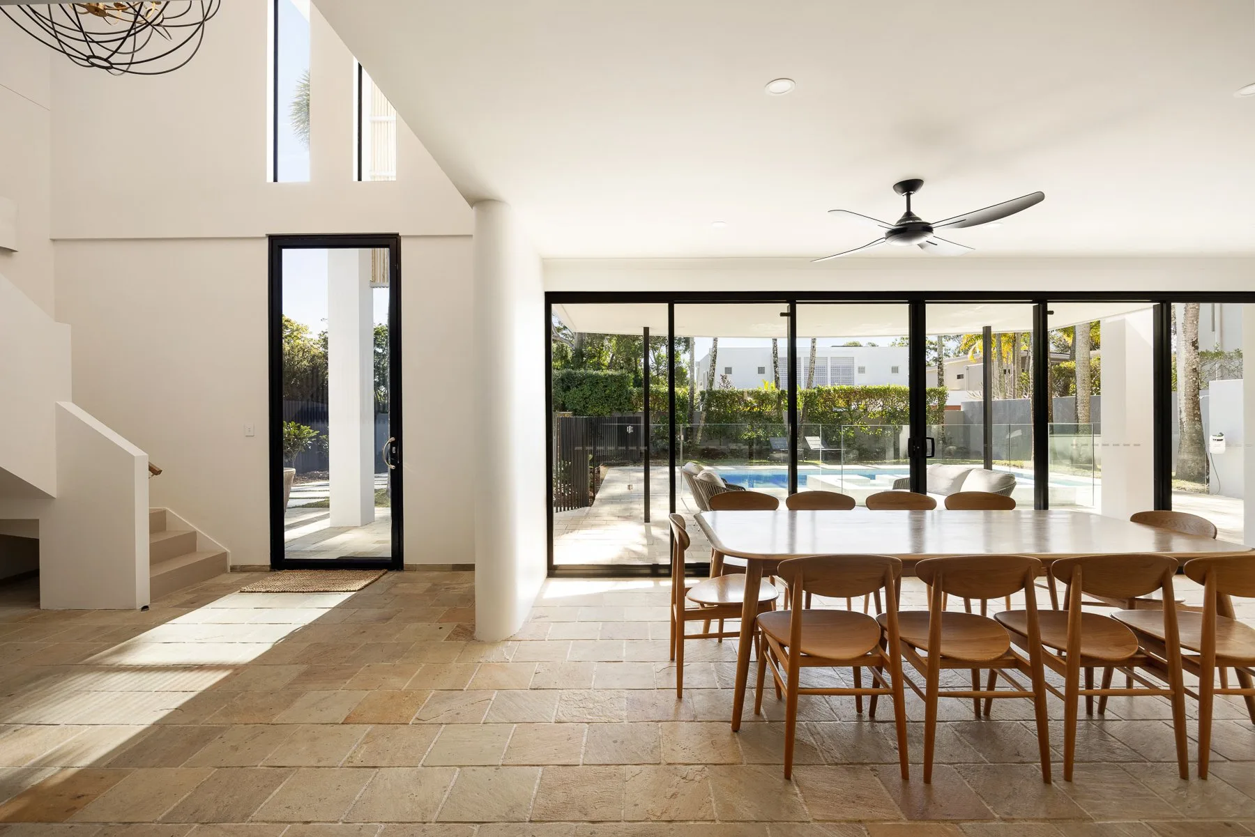 A bright dining area opens onto a patio through wide glass doors.