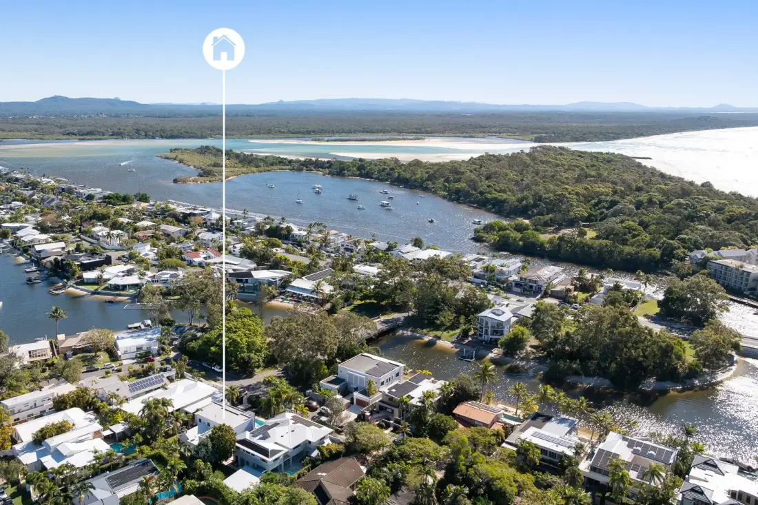 Aerial view of a coastal town beside a winding inlet and wooded shoreline.