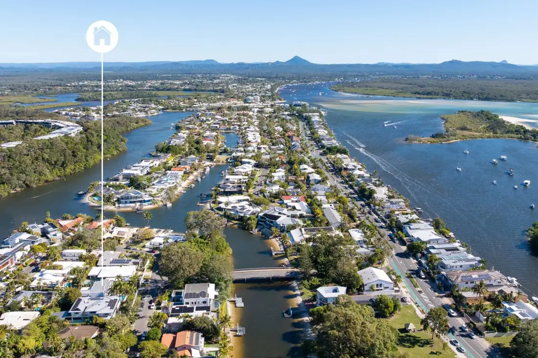 Aerial view of a coastal town between waterways, with boats on the water.