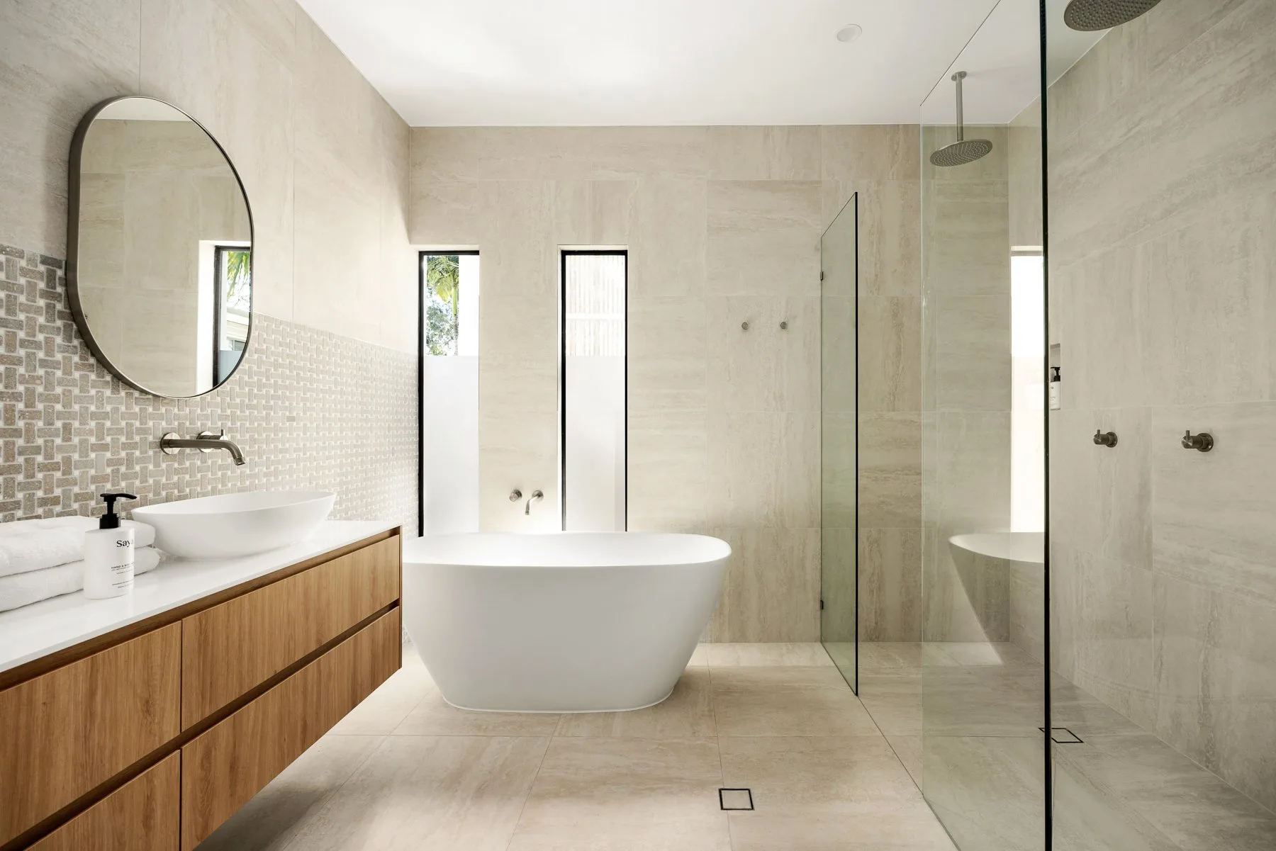A modern bathroom with a freestanding bathtub and glass shower.