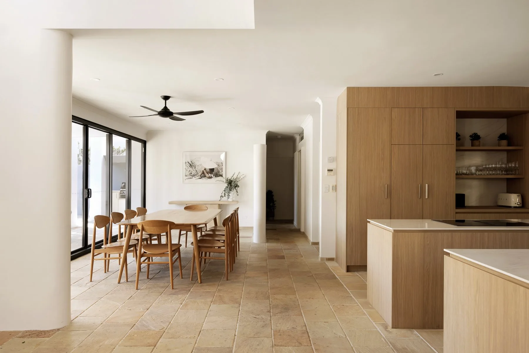 An open dining and kitchen area with a wooden table and cabinetry.