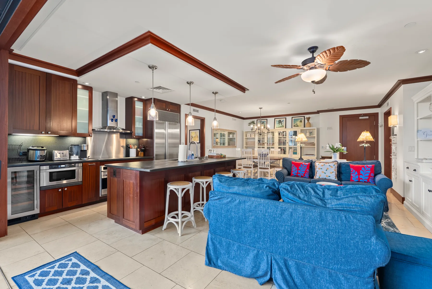 Cocina y sala de estar de concepto abierto, con asientos azules y una isla de cocina.