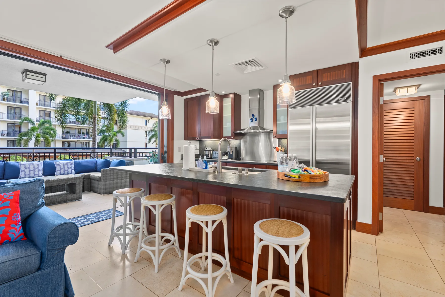 Una cocina abierta con una isla central y asientos junto a una ventana grande.
