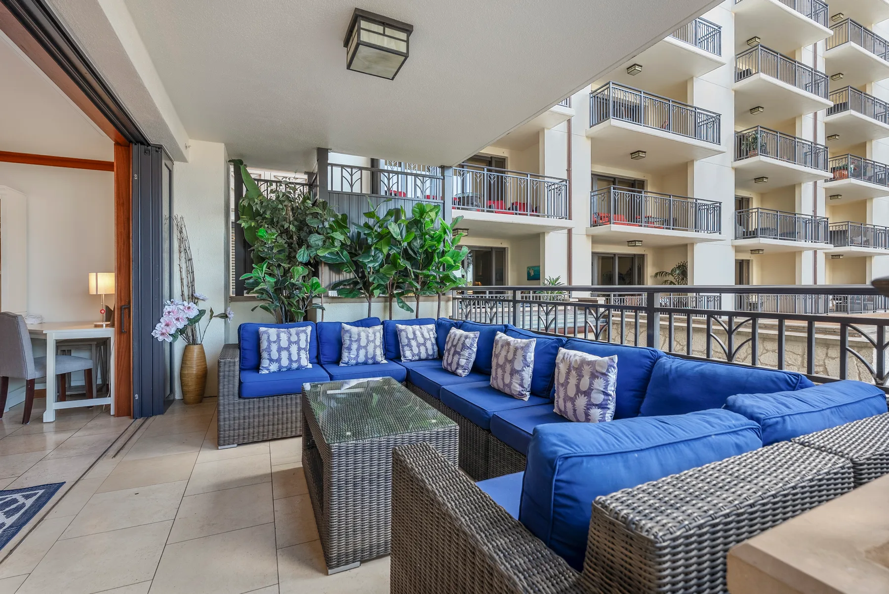 Una zona de estar cubierta con asientos azules y vista a los balcones cercanos.