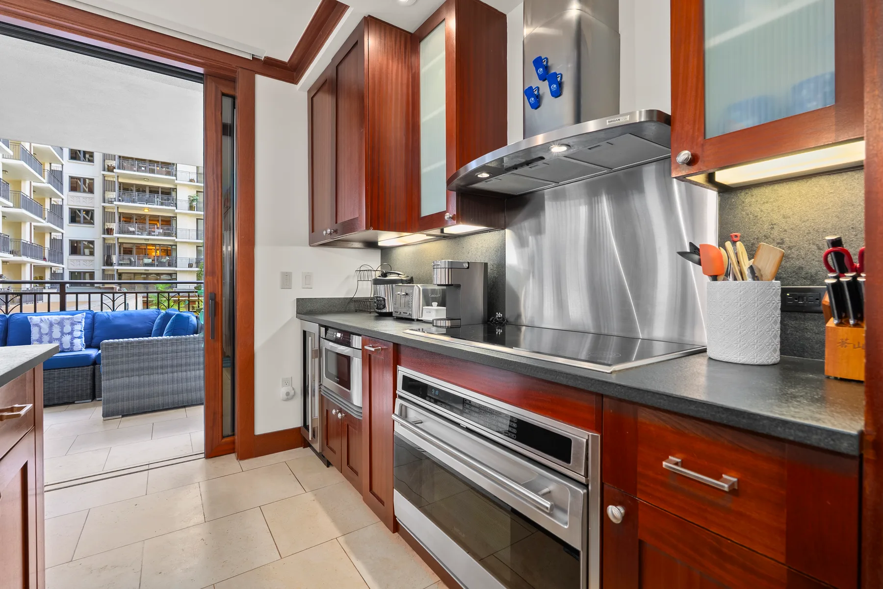 Una cocina moderna con encimeras oscuras y una estufa de acero inoxidable.