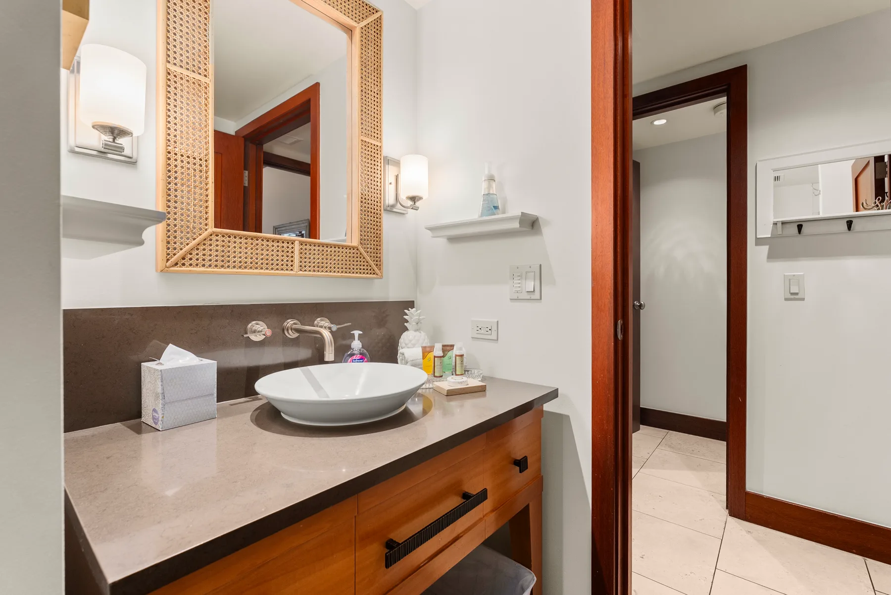 Un tocador de baño con lavabo y un espejo grande enmarcado.