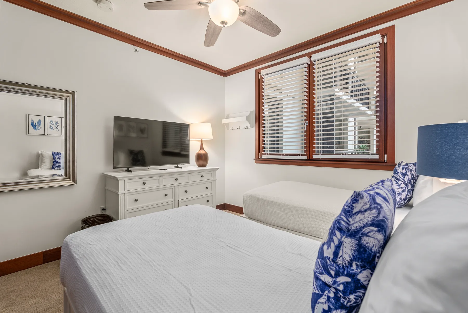 Un dormitorio con camas, un televisor y una ventana con persianas.