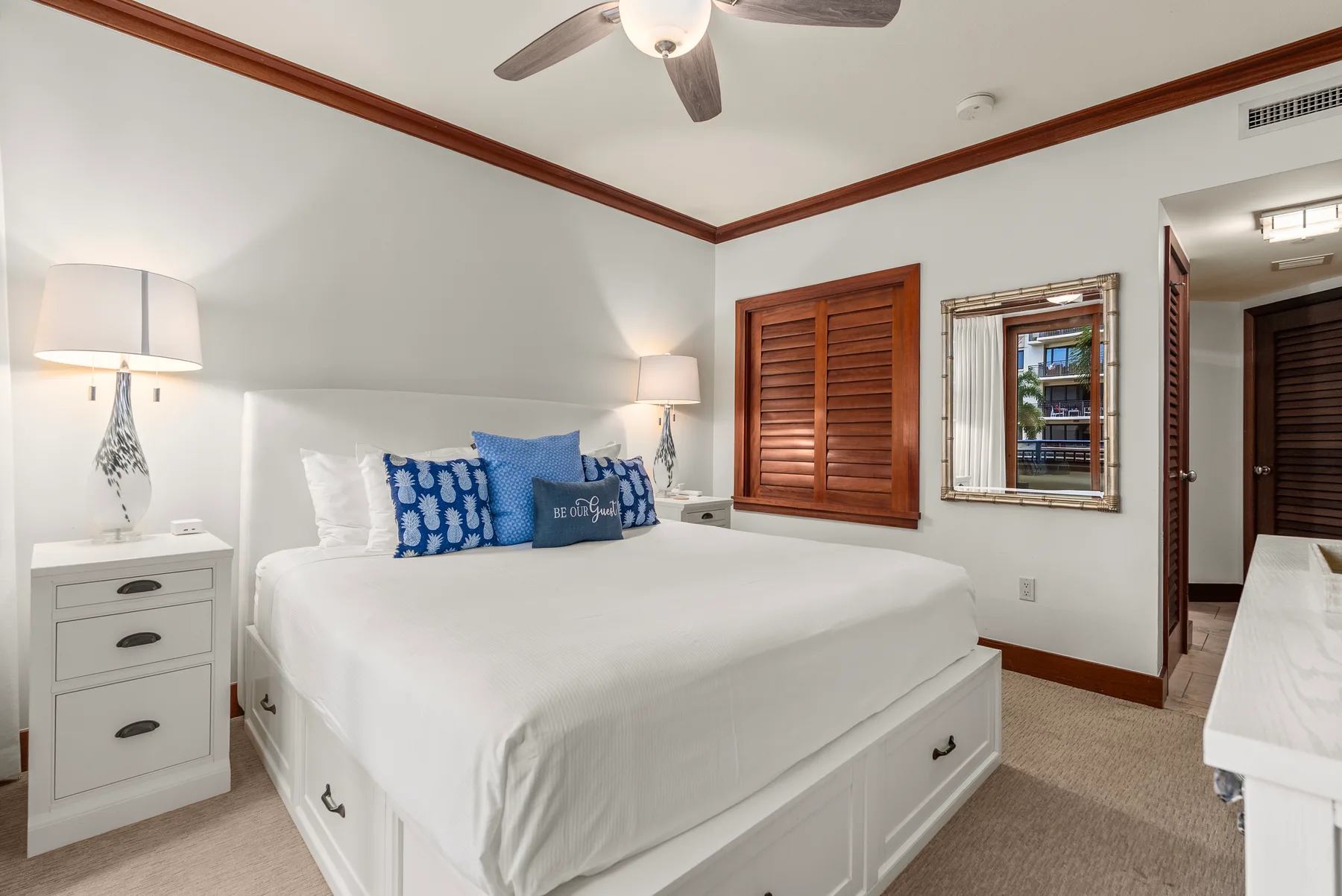 Un dormitorio con una cama bien tendida y cojines decorativos azules.