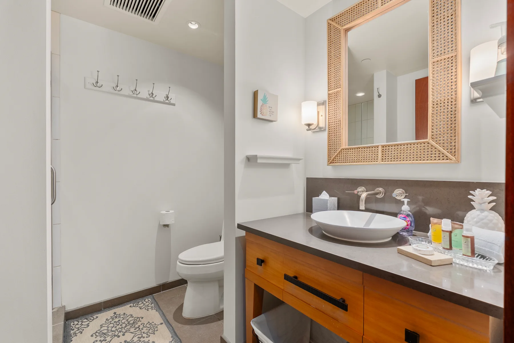Un baño luminoso con tocador, lavabo y un gran espejo enmarcado.