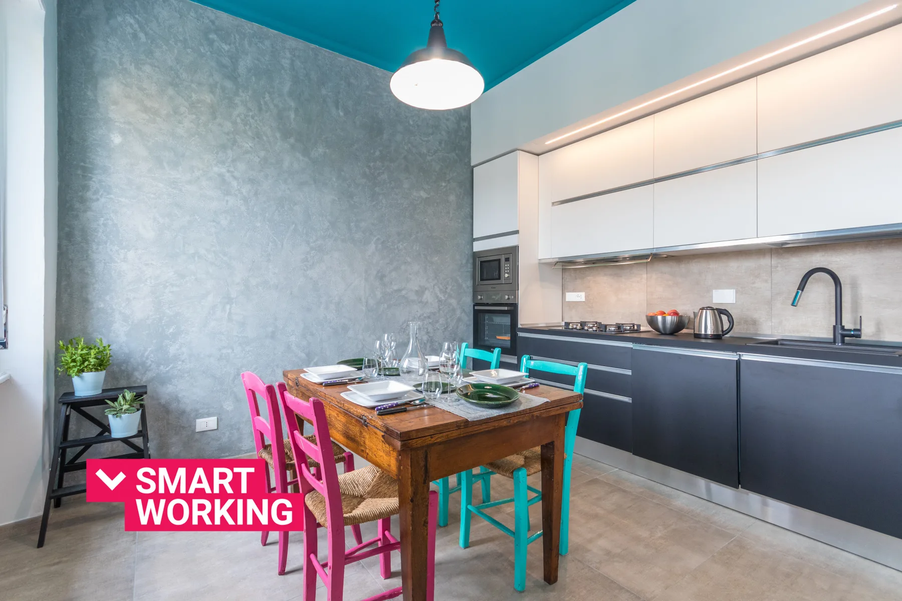 A dining area with a wooden table and colorful chairs beside a modern kitchen.