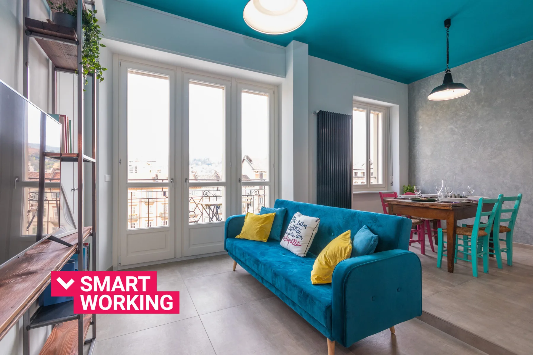 A bright living and dining area with blue seating and large windows.
