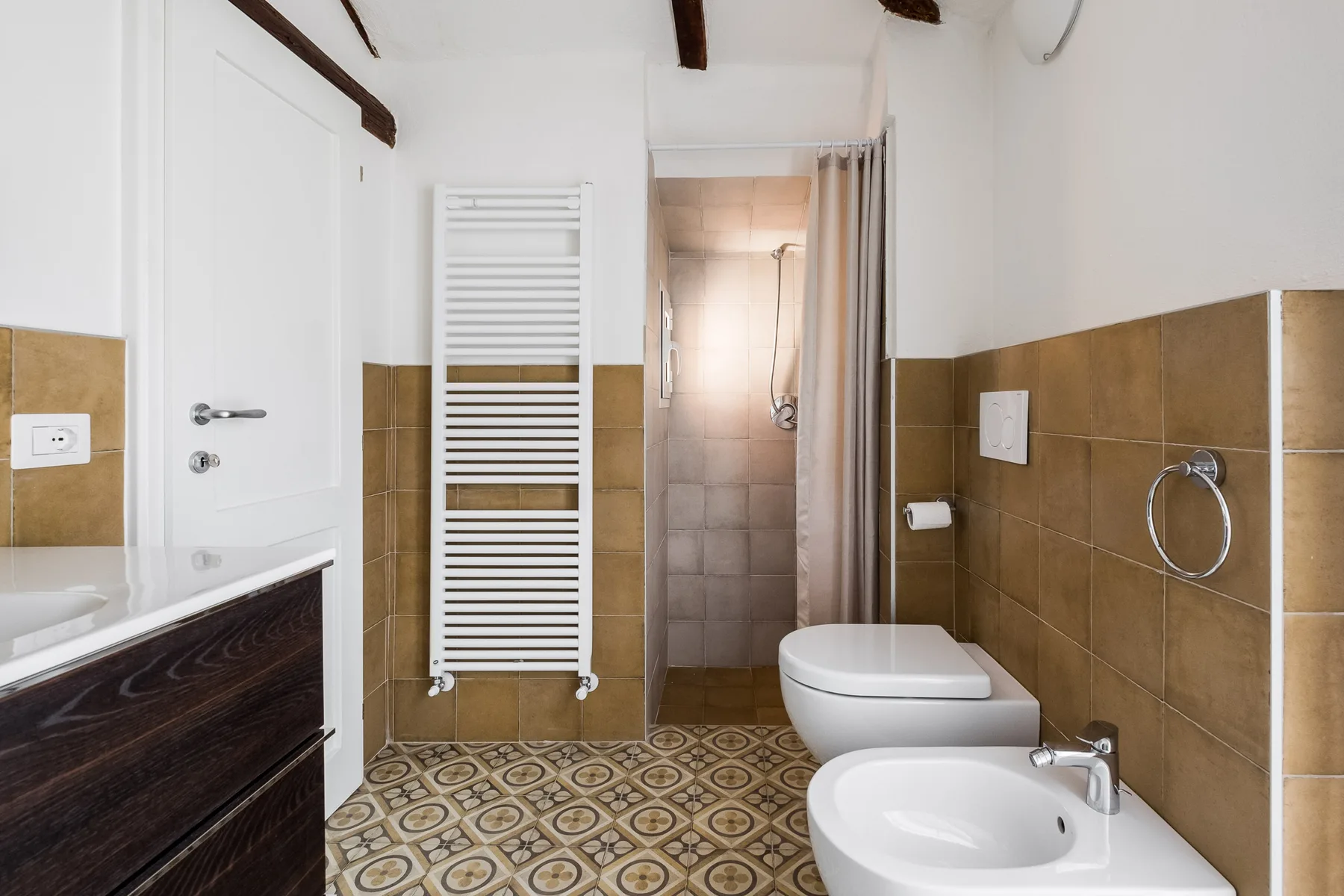 Un baño alicatado con ducha, inodoro y lavabo.