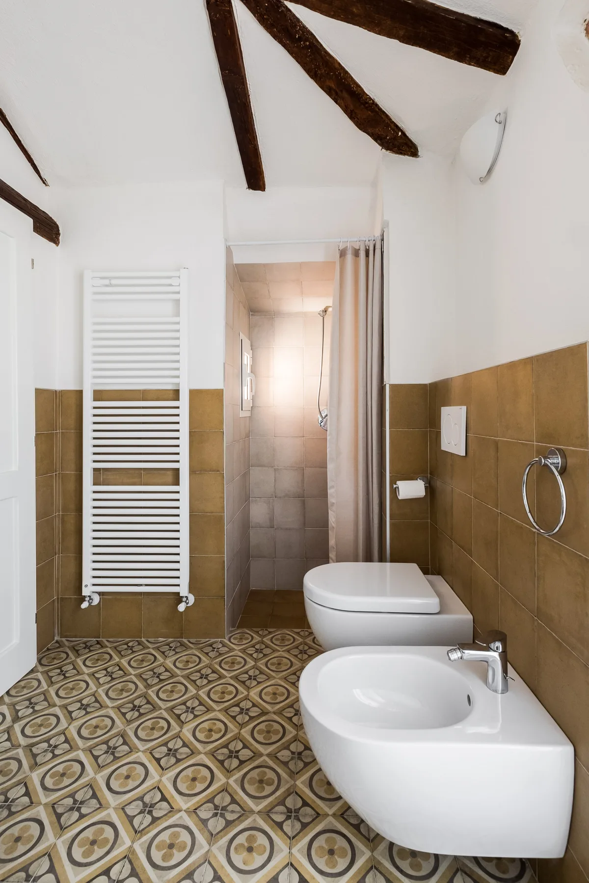 Un baño alicatado con lavabo, inodoro y ducha.