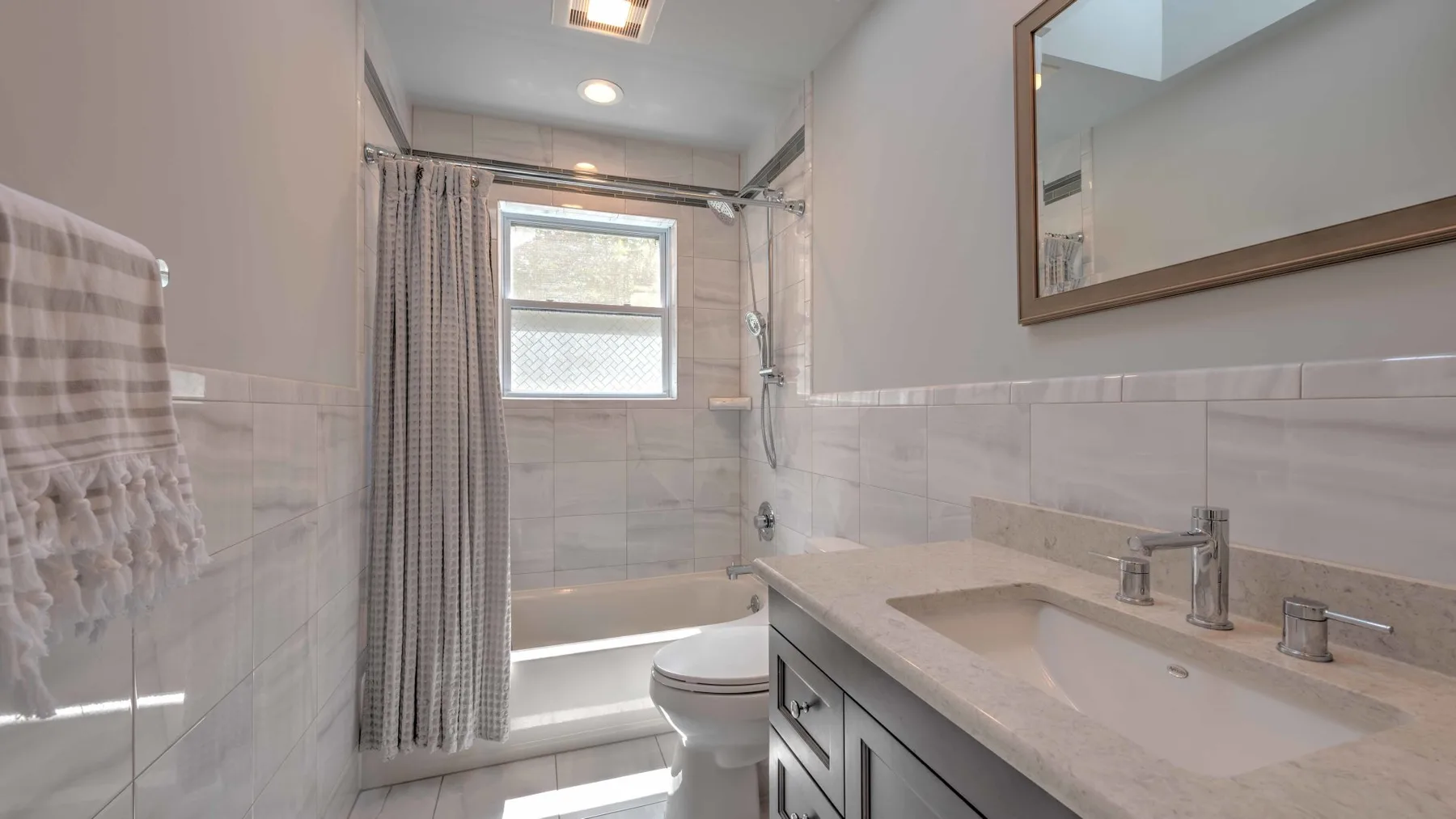 Un baño con lavabo, inodoro y ducha con cortina.