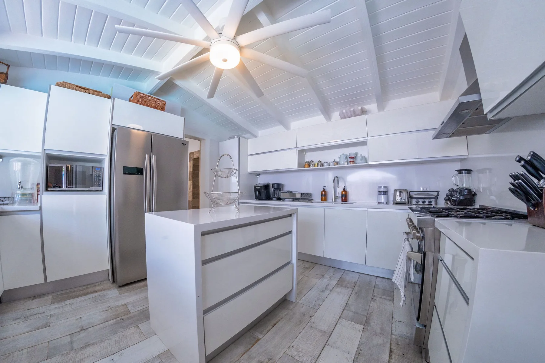 A bright kitchen with a central island and white cabinetry.