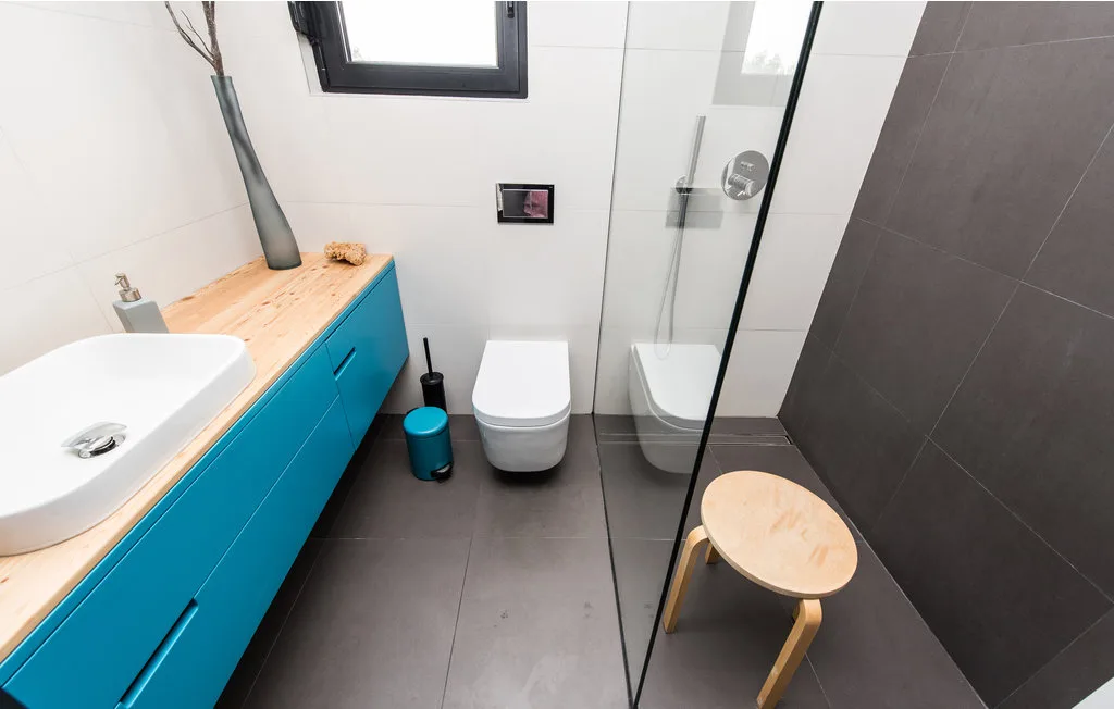 Un baño moderno con lavabo, inodoro y ducha de vidrio.