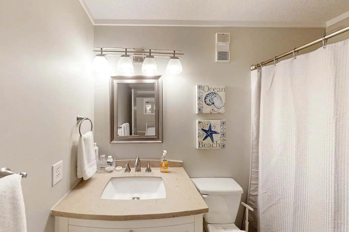 Un baño con lavabo, inodoro y cortina de ducha.
