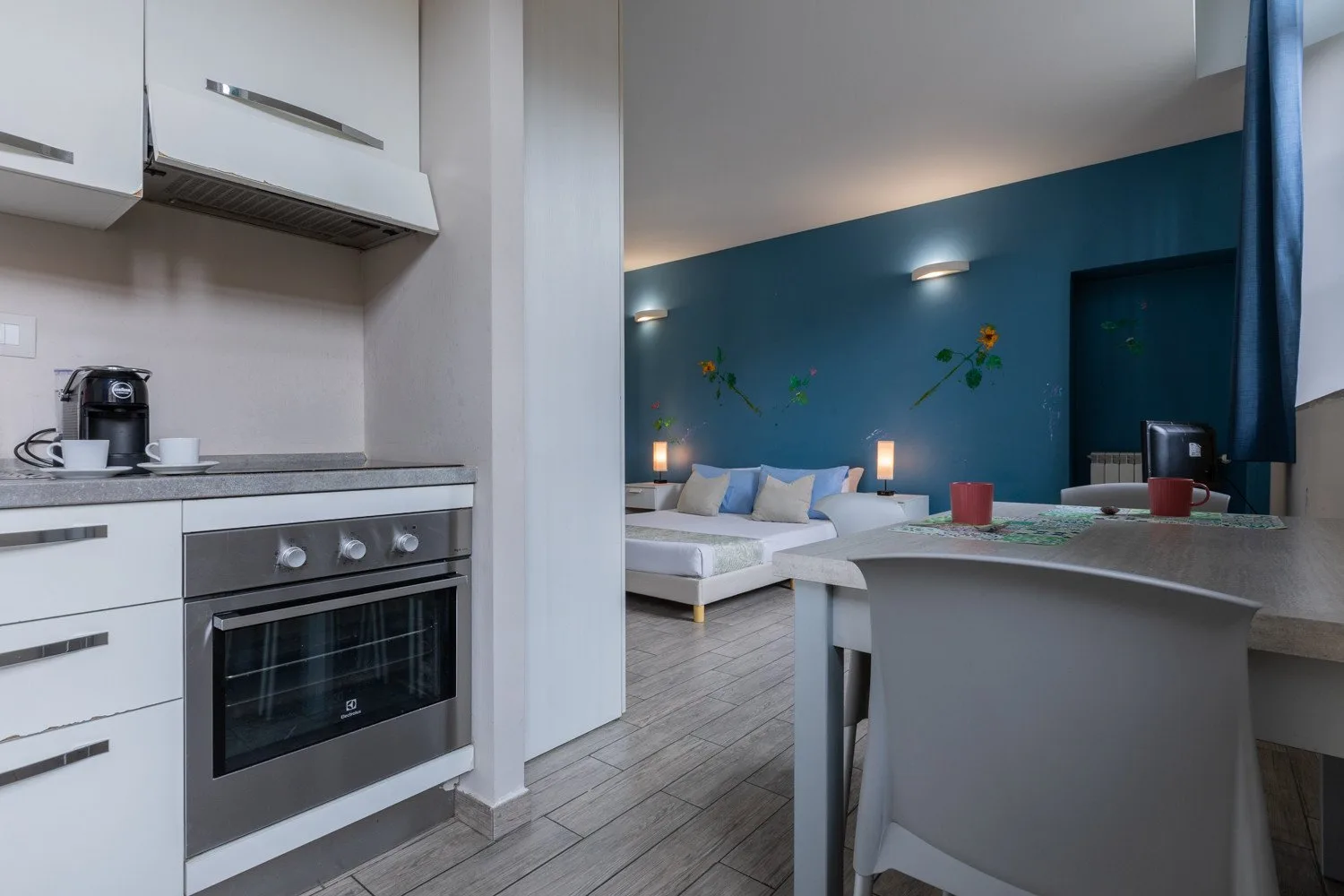 Una cocina moderna se abre a un comedor con una pared azul.
