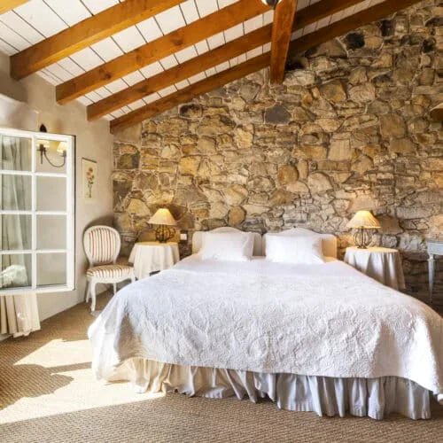 Habitación de lujo con paredes de piedra y vigas vistas