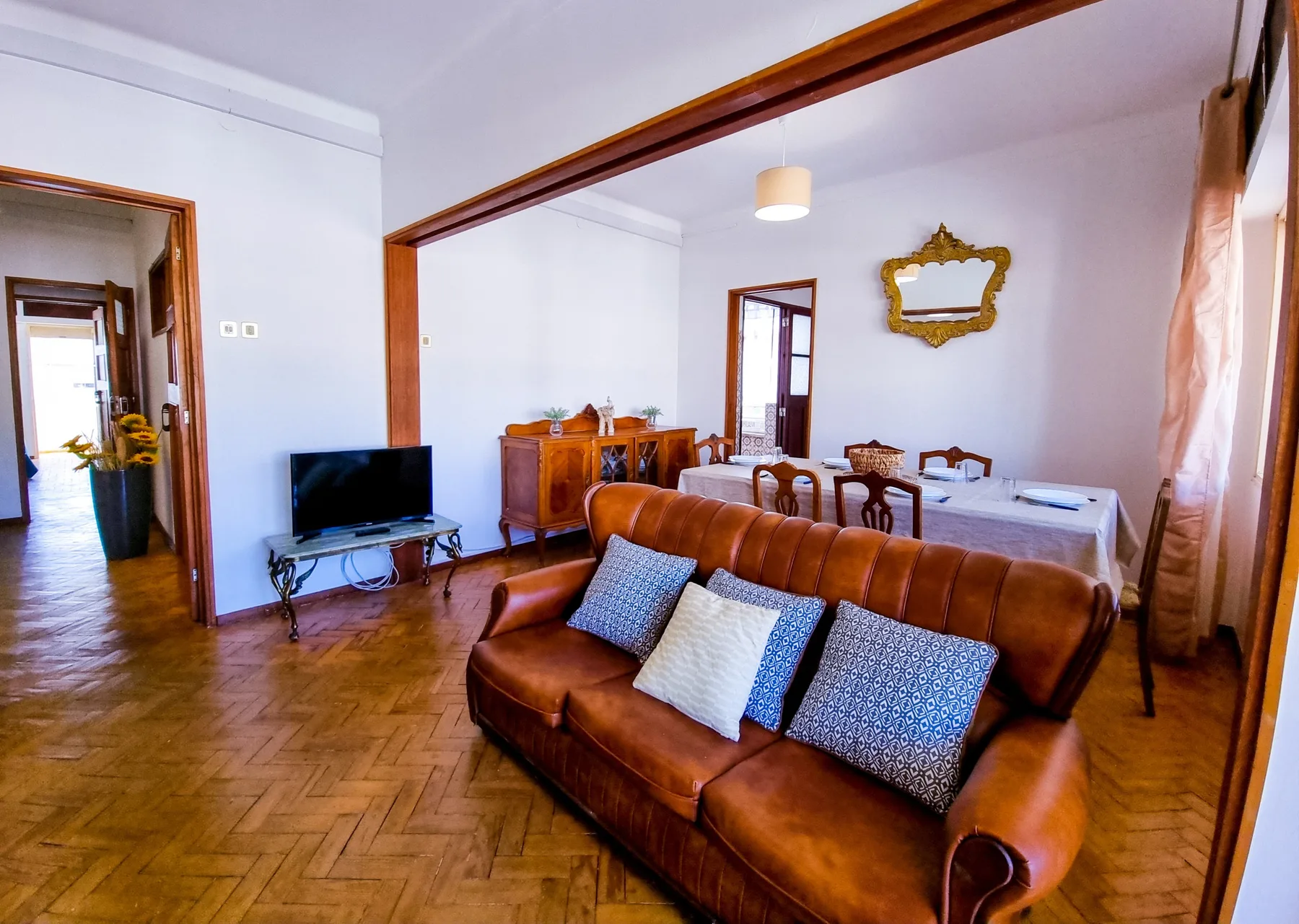 Sala de estar y comedor con asientos marrones y una mesa de comedor.