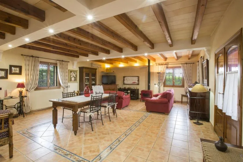 A spacious living and dining room with a wooden table and red seating.