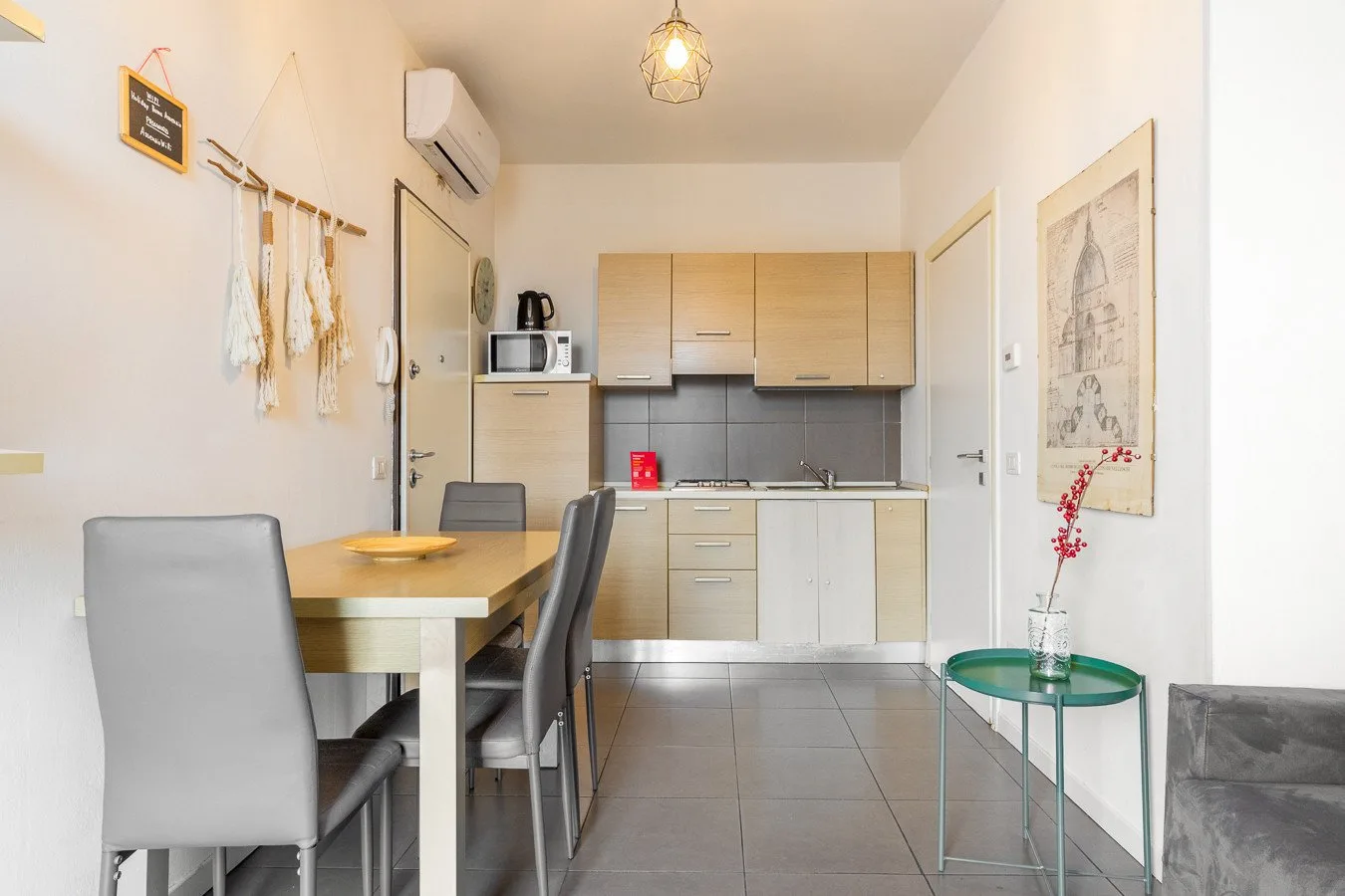 Una cocina compacta con zona de comedor y una mesa junto a los armarios.