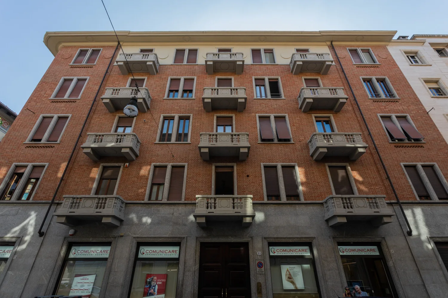 Un edificio de ladrillo con balcones y escaparates a nivel de calle.