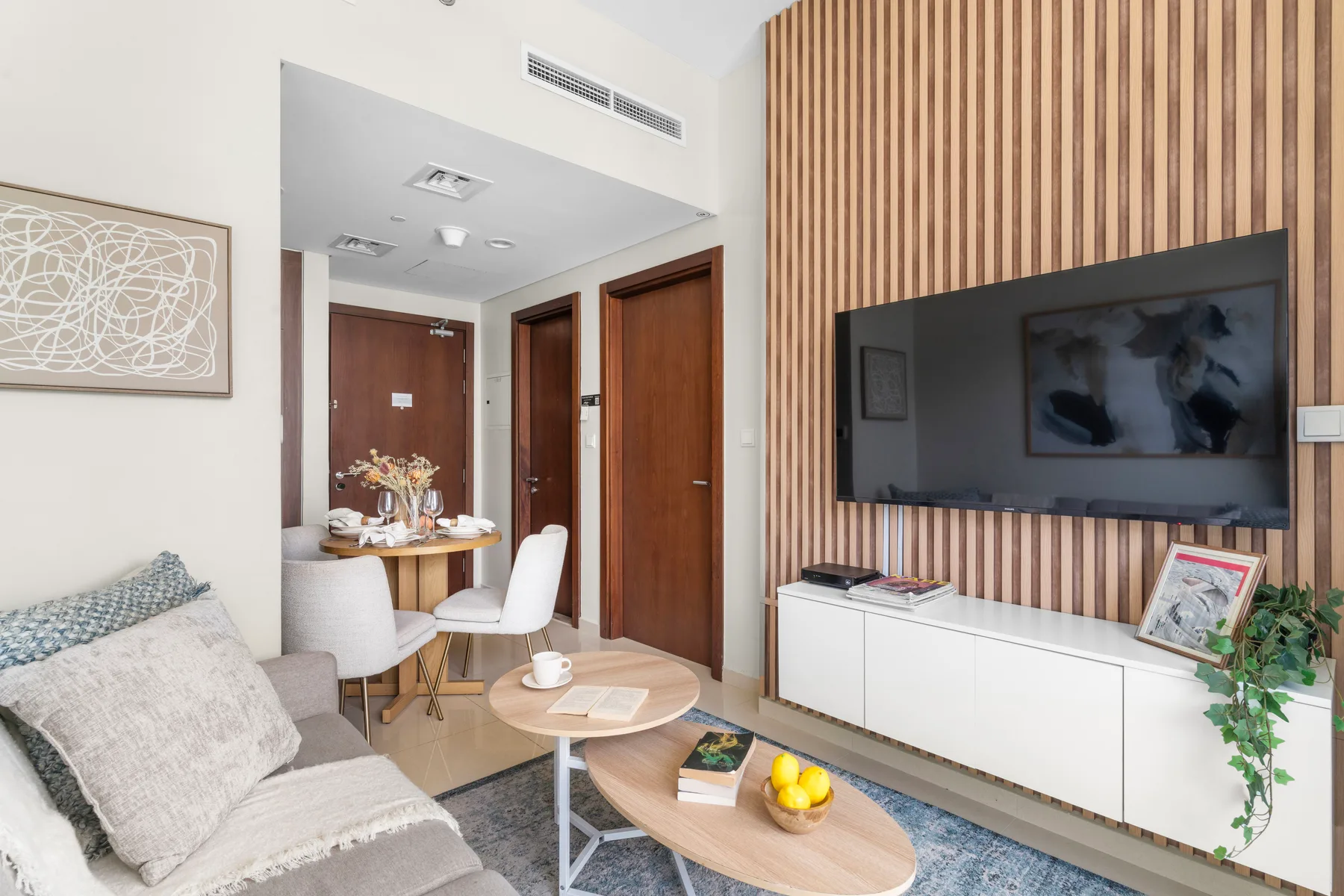 Una sala luminosa con asientos, un televisor y una mesa de comedor.