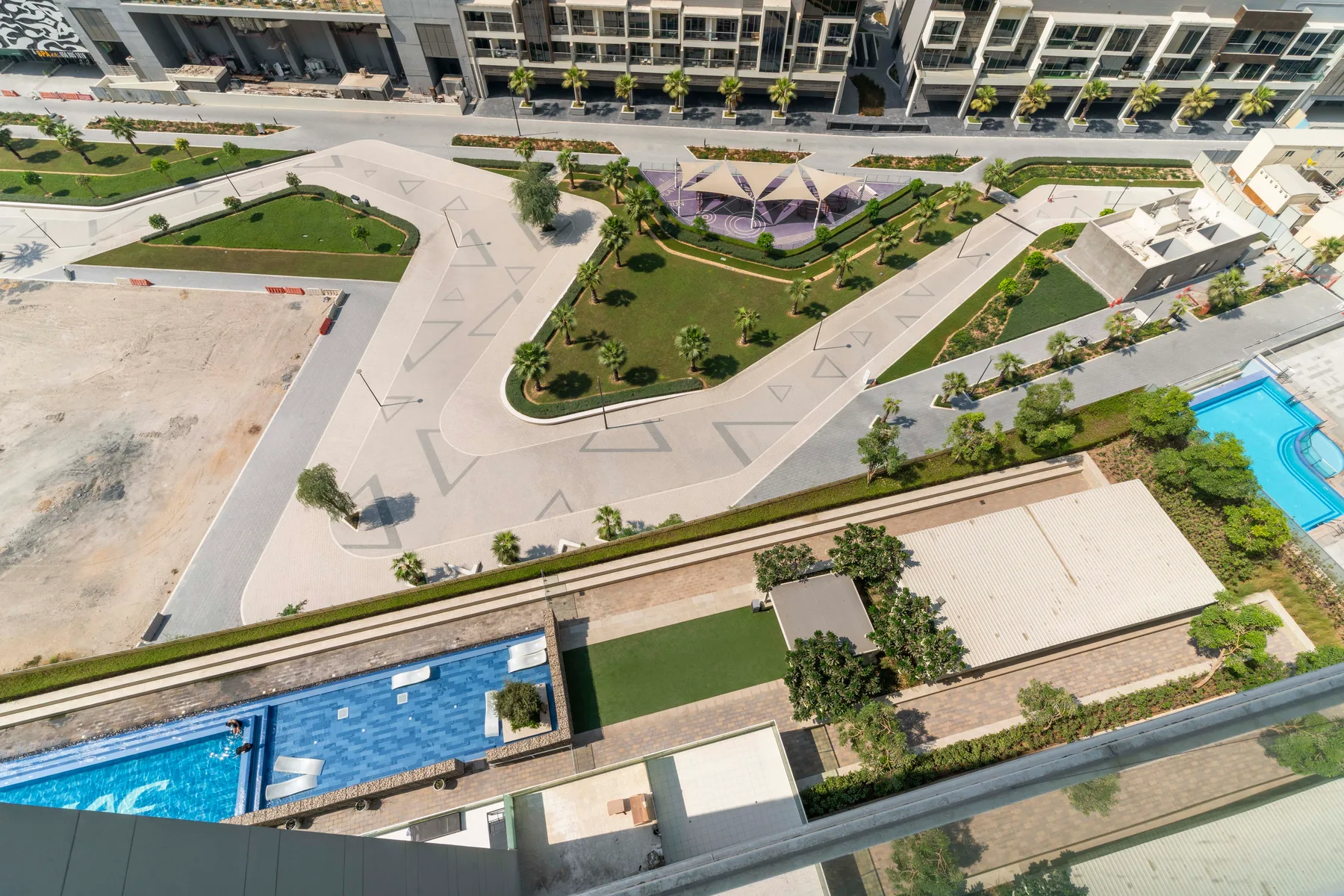 Vista aérea de jardines, caminos pavimentados y piscinas.
