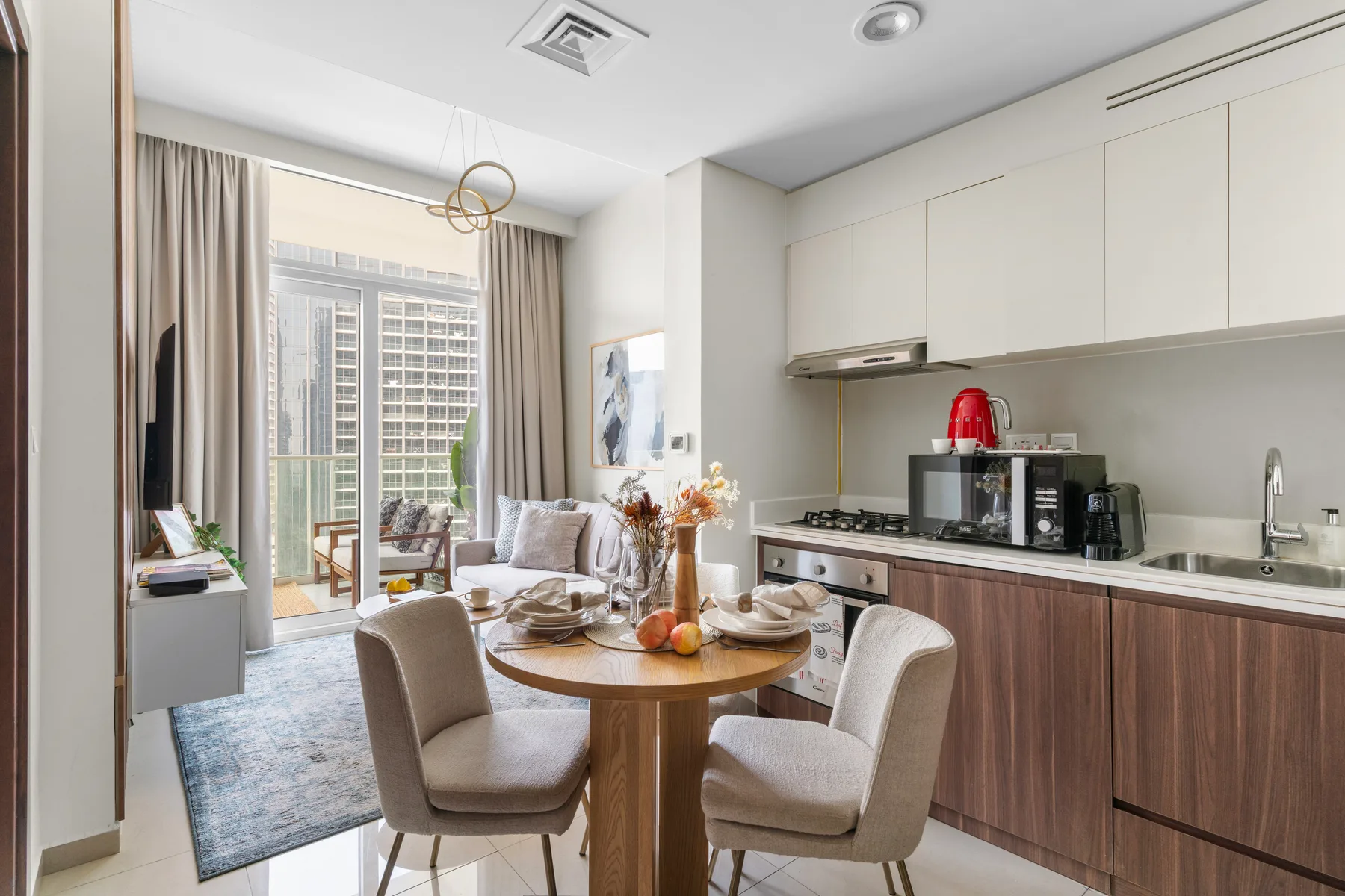 Una luminosa zona abierta de estar y comedor con cocina y ventanales.