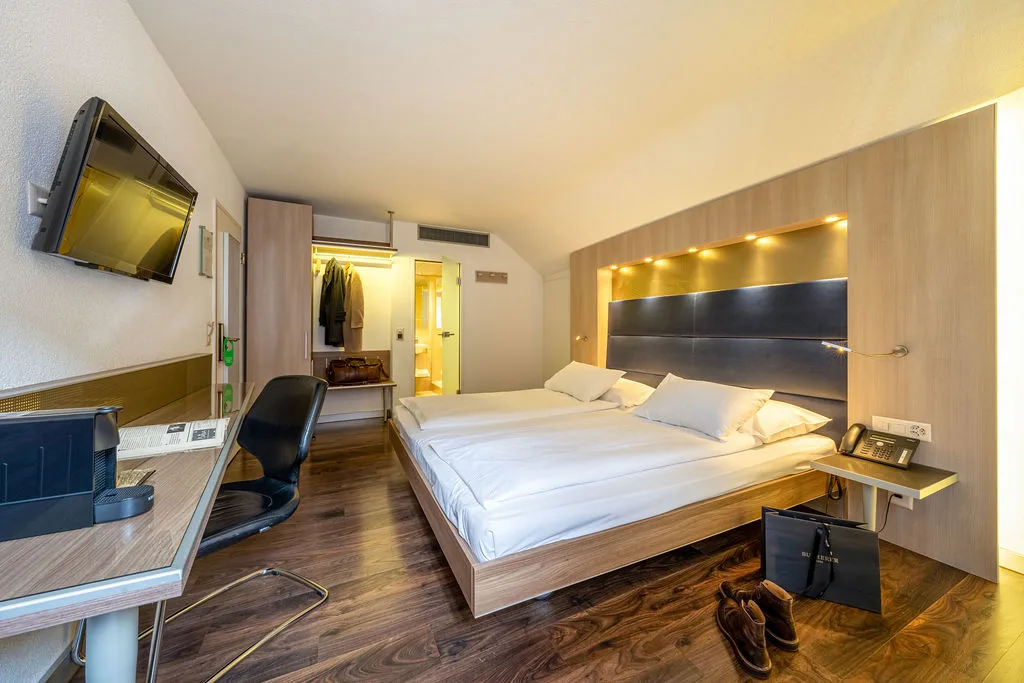 Habitación doble con suelo de parquet y un escritorio pequeño