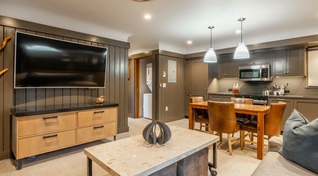 Una cocina y comedor de planta abierta con una isla grande y una mesa de madera.