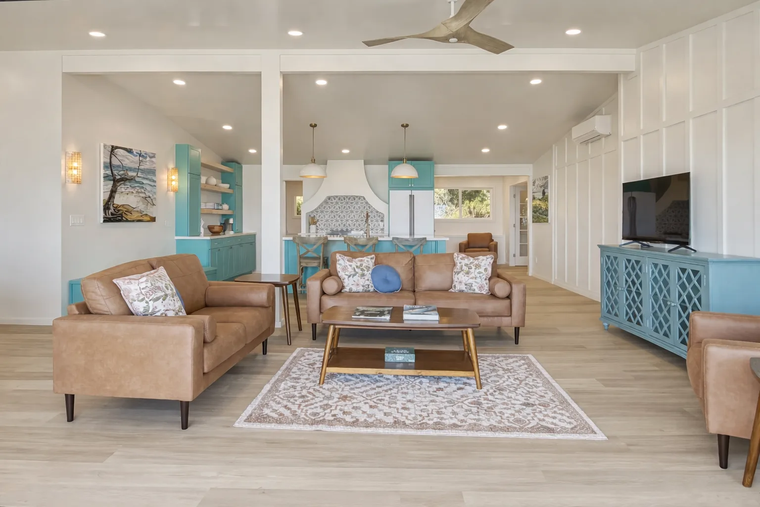 A living room with seating around a coffee table and a television along the wall.