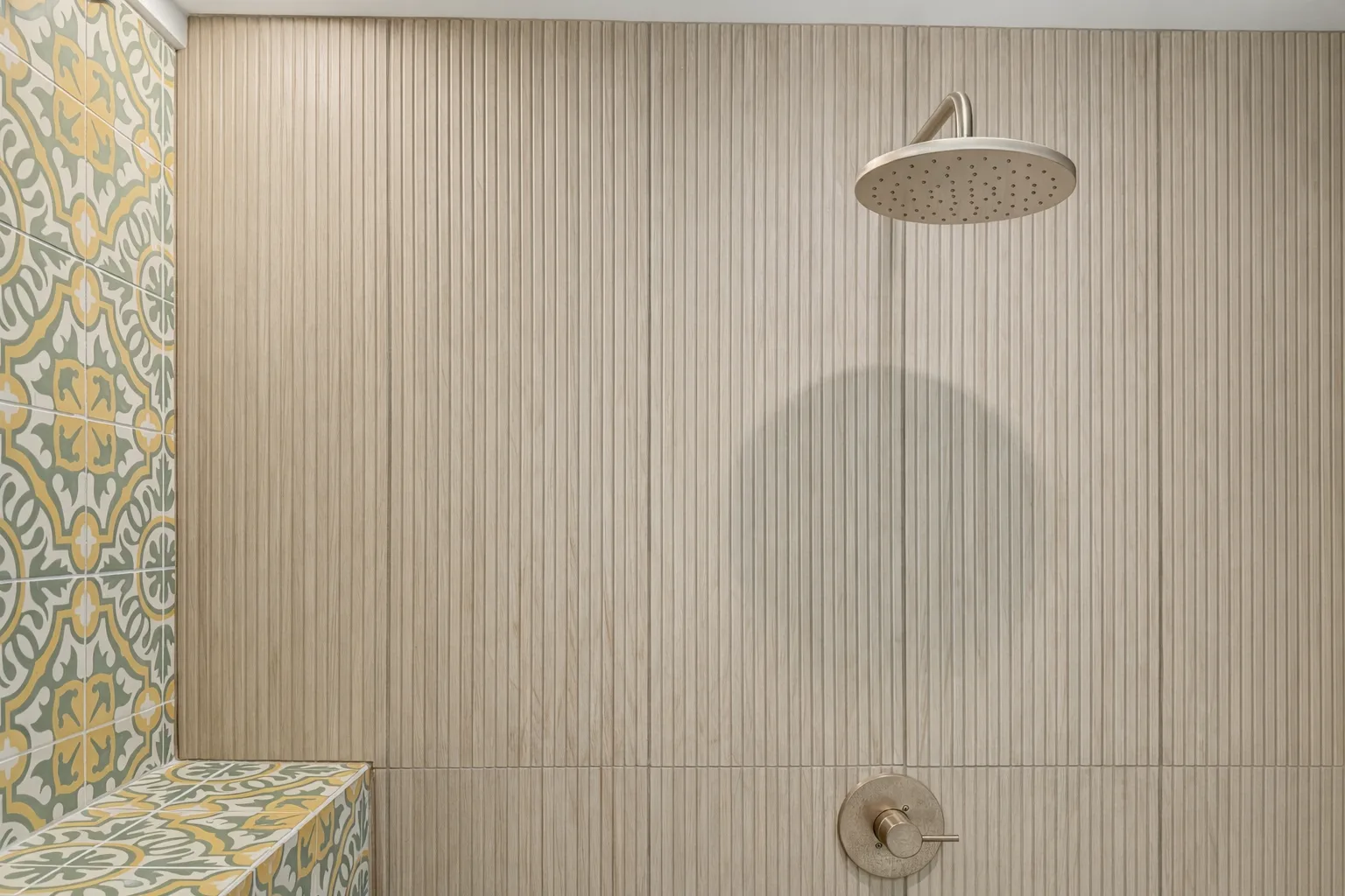 A tiled shower with a round overhead showerhead.
