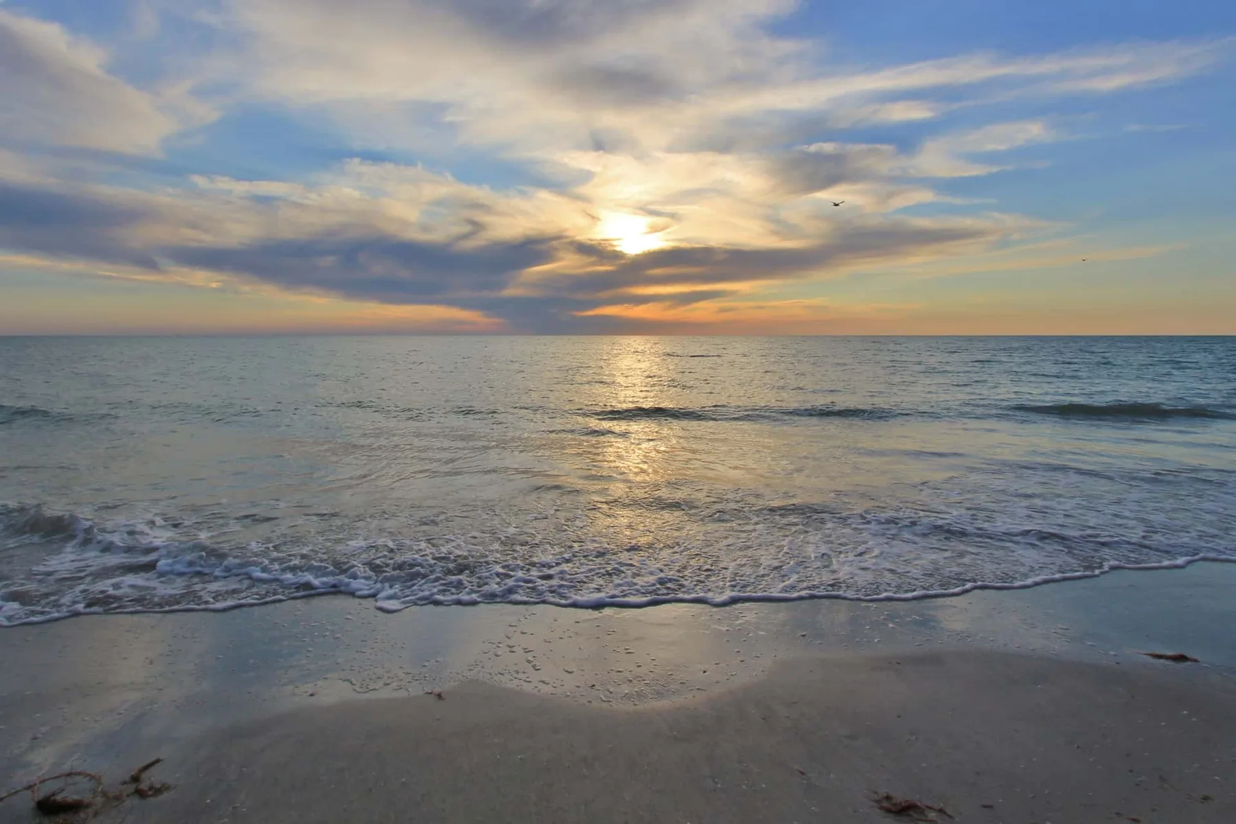 A beach at sunset, with gentle waves reaching the shore.