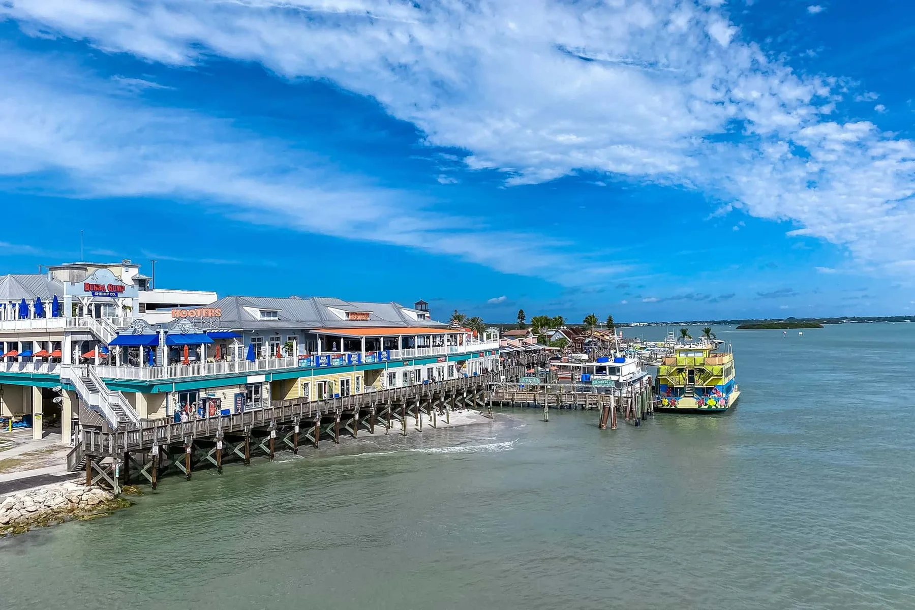 A waterfront pier lined with colorful buildings and a boat on the water.