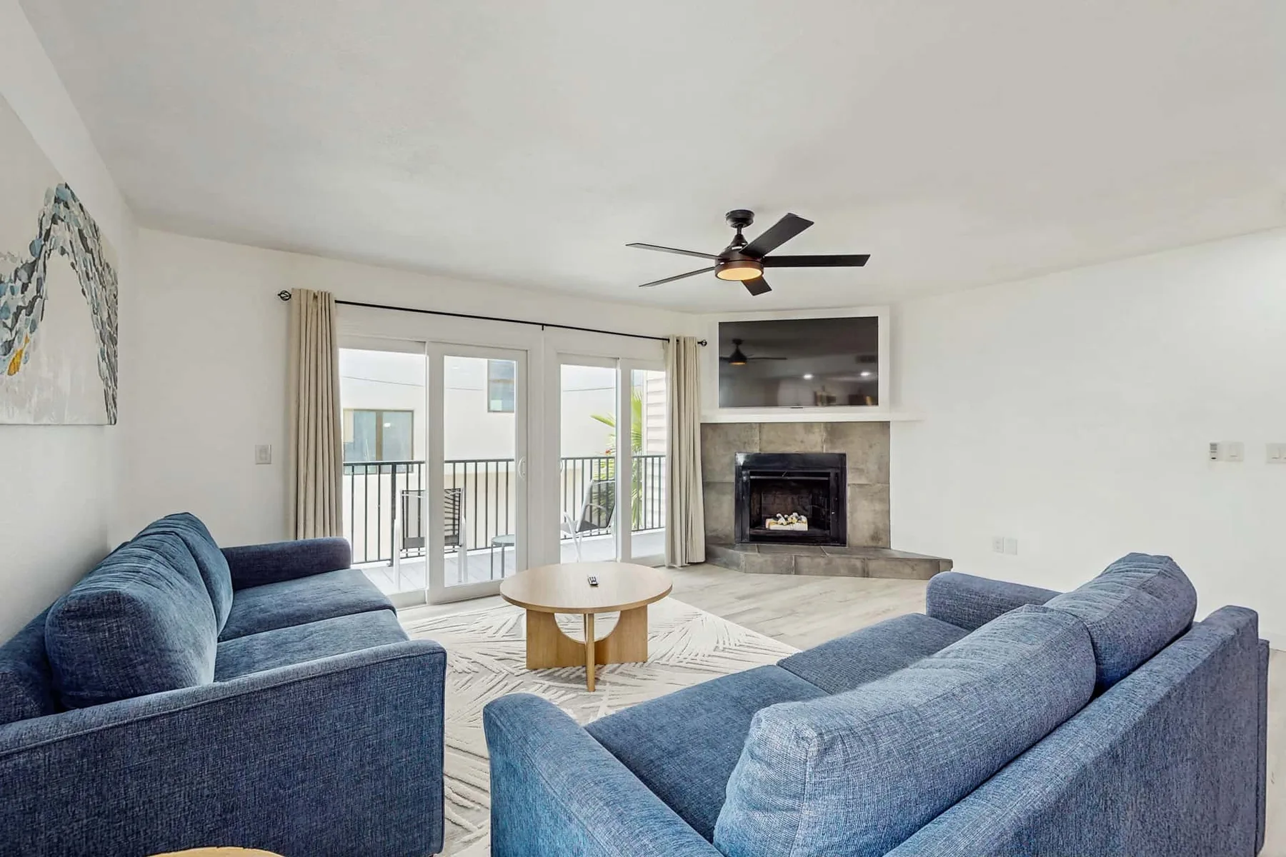 A living room with blue seating, a coffee table, and a fireplace.