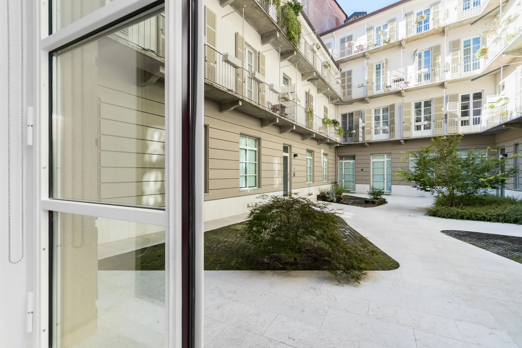 A landscaped courtyard with walkways and surrounding multi-story buildings.