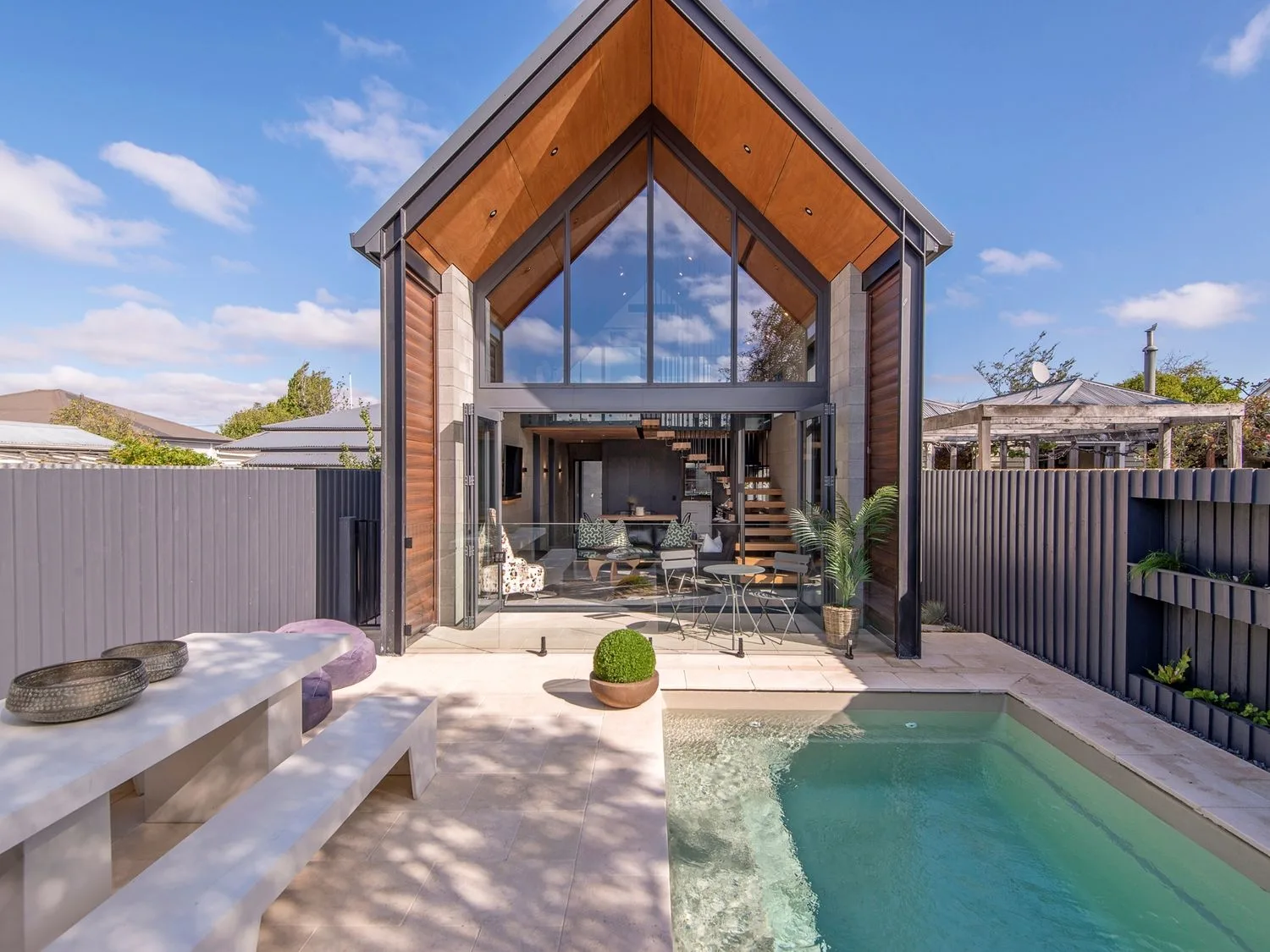 A courtyard with a swimming pool and a modern house with large glass windows.