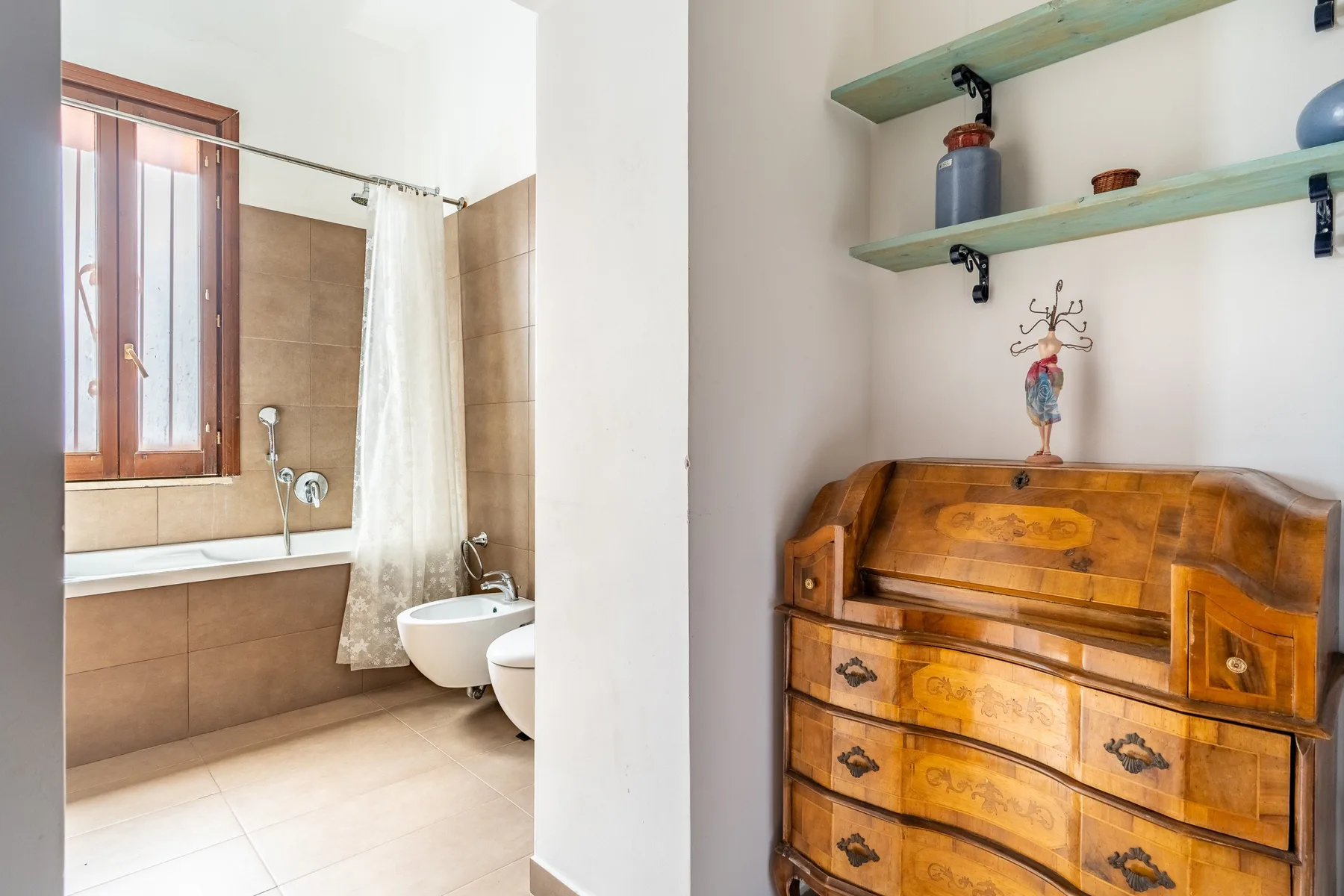 Un baño con bañera y una cómoda de madera al lado.