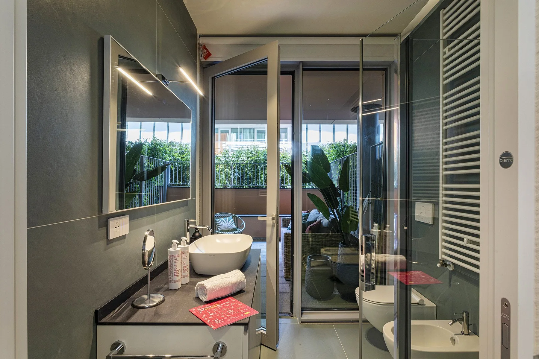 A modern bathroom with a vanity, sink, and glass shower enclosure.