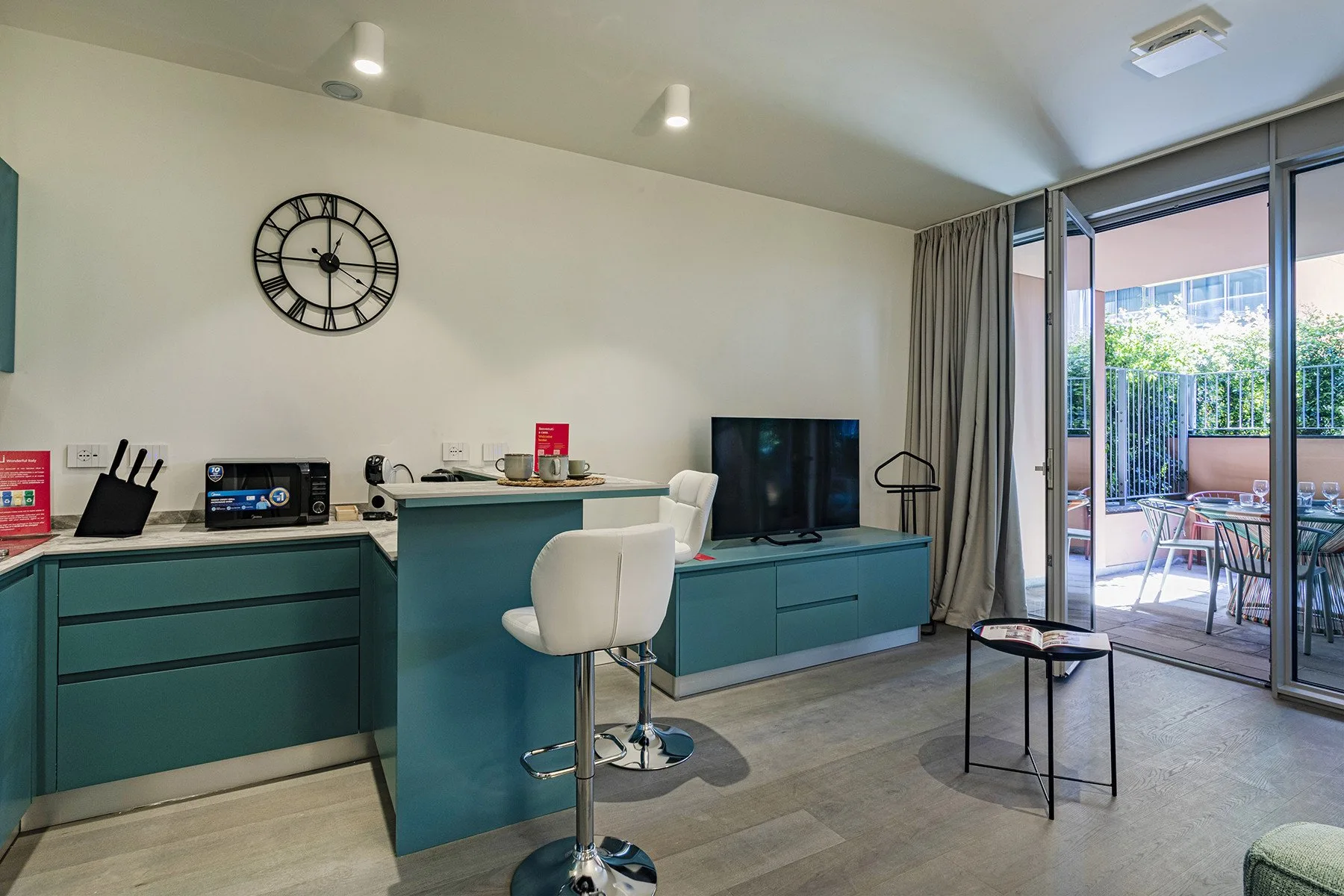 A modern living area with a counter, seating, and glass doors opening to a patio.
