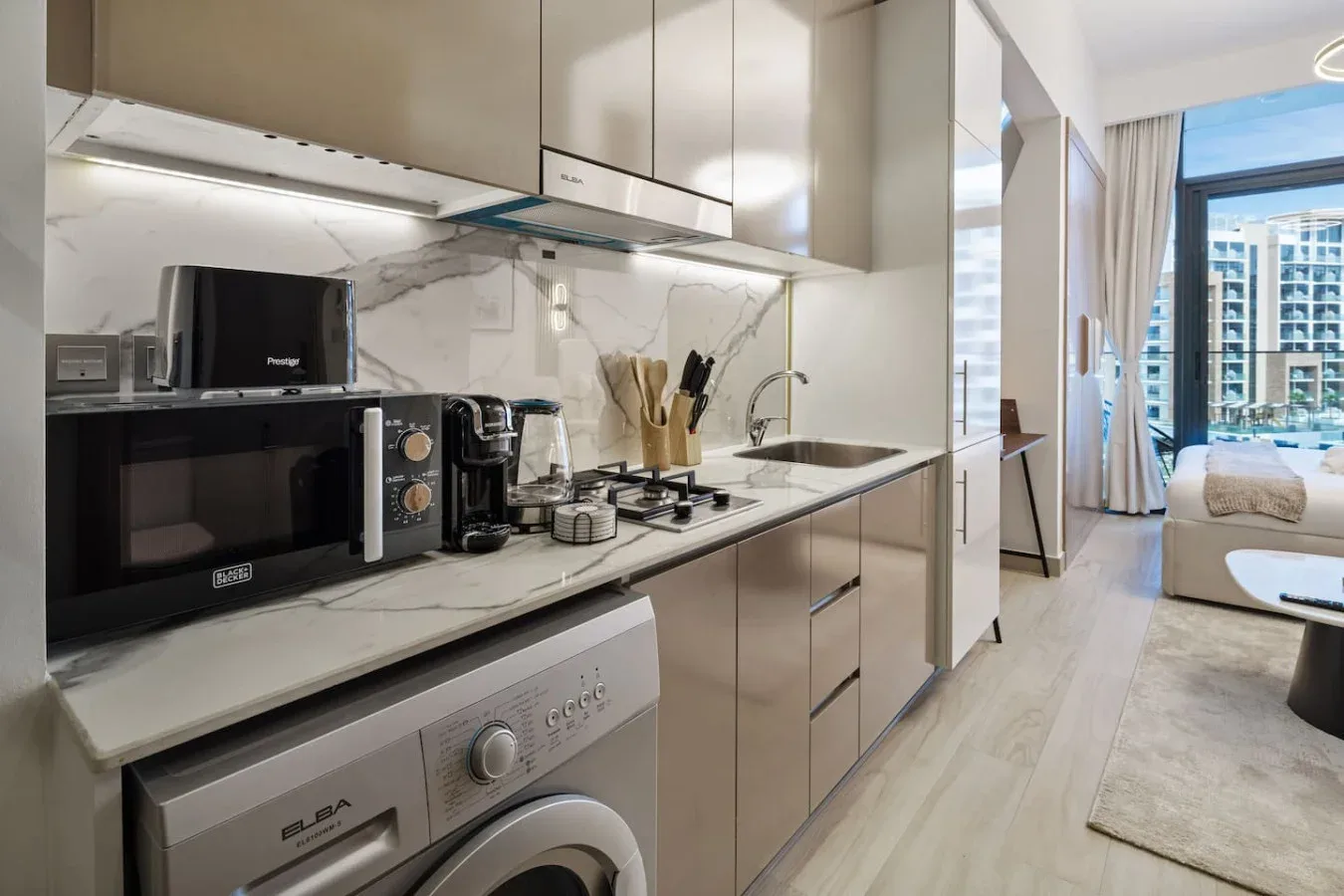 Una cocina moderna con una encimera, electrodomésticos y un fregadero.