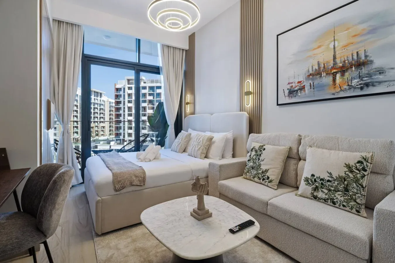 Una sala luminosa con una zona de estar junto a grandes ventanales.