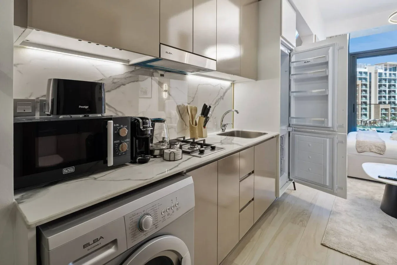 Una cocina moderna con encimera, fregadero y lavadora.
