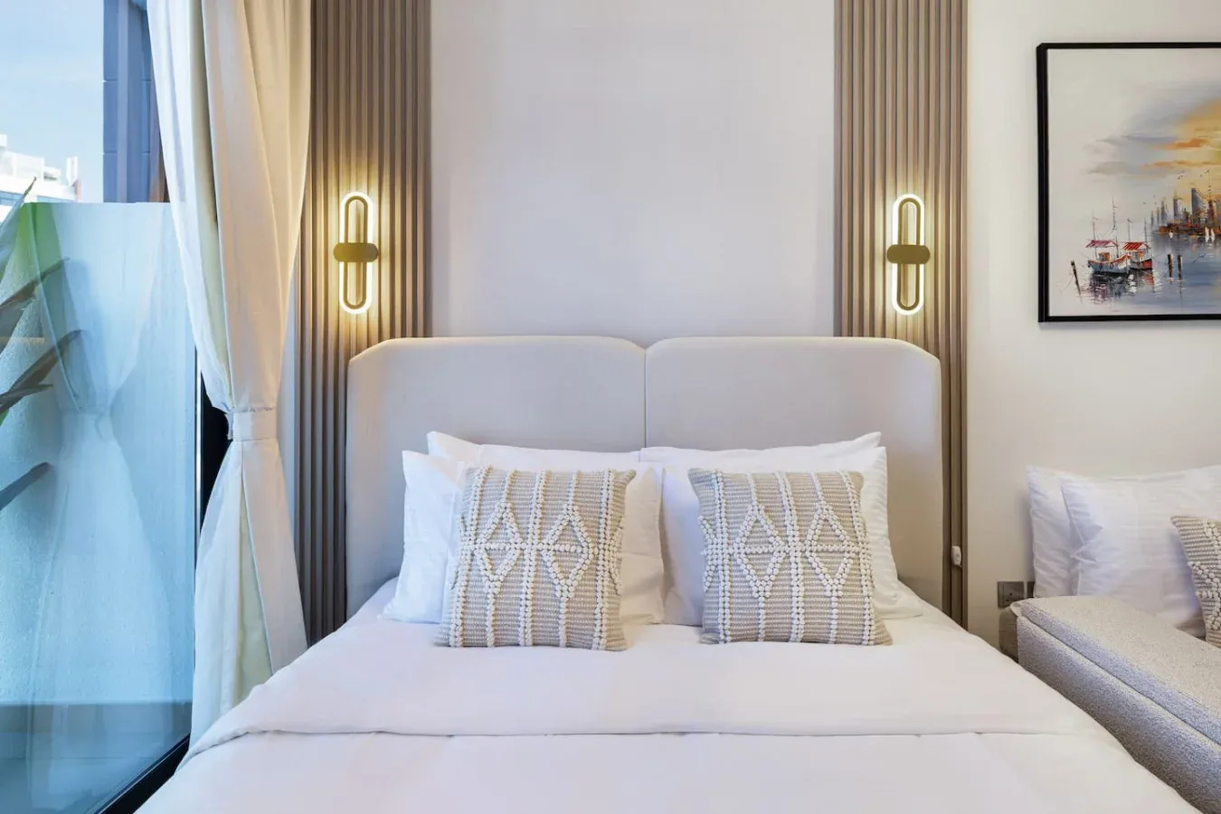 Un dormitorio con una cama bien tendida y cojines decorativos.