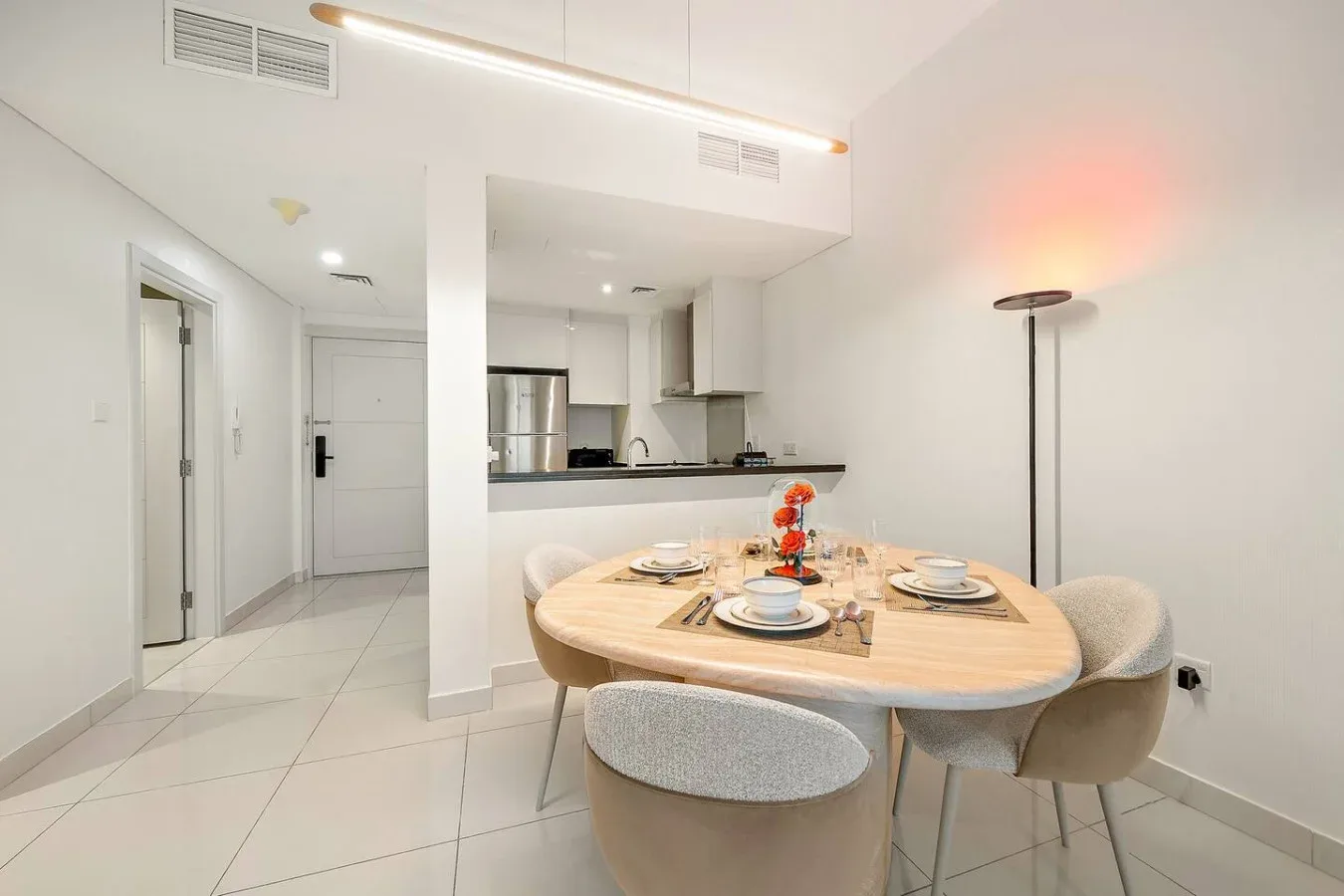 Un comedor con la mesa puesta está junto a una cocina abierta.