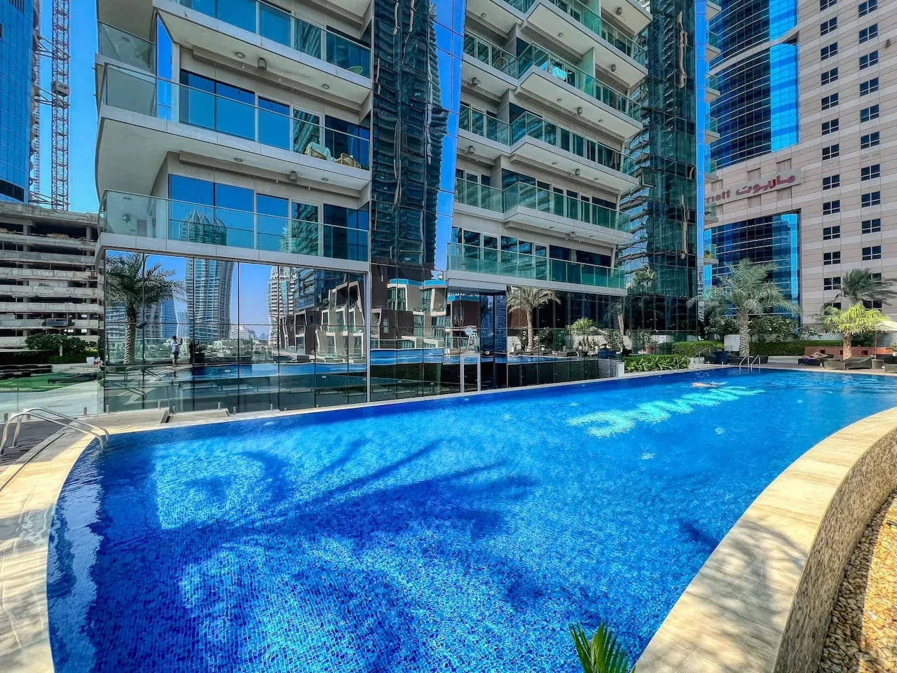 Una piscina al aire libre está frente a edificios modernos de gran altura.