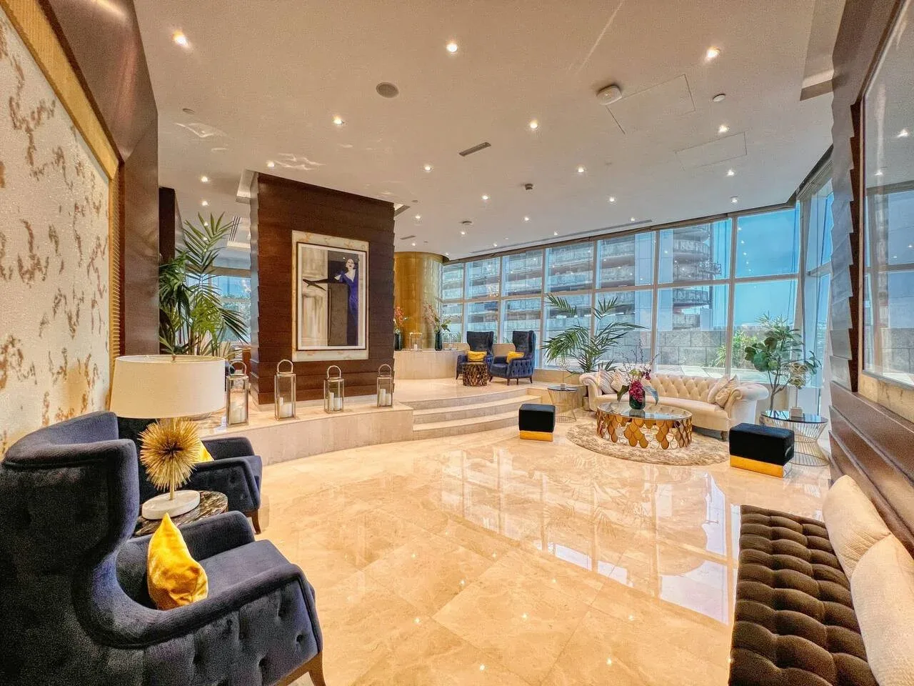 Un amplio salón con asientos junto a ventanales de piso a techo.